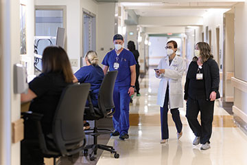 Kentucky Neuroscience Institute providers walk through a hospital hallway together. 