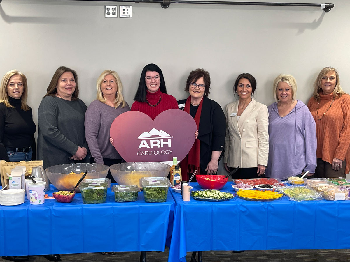 Employees and staff of ARH gathered for a photo behind a banquet table.