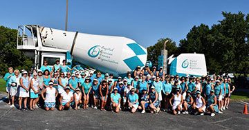 Photo of Tee it Up with C.O.C.O. participants posing in front of a cement mixer