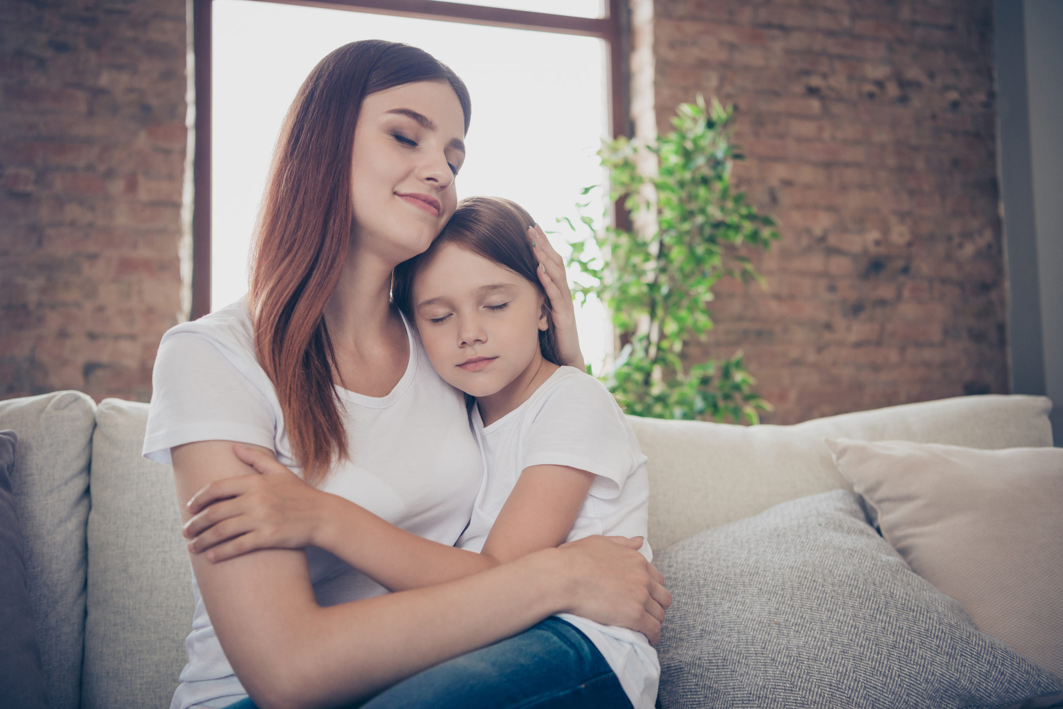 A young mother comforts her daughter, about 7 years old.