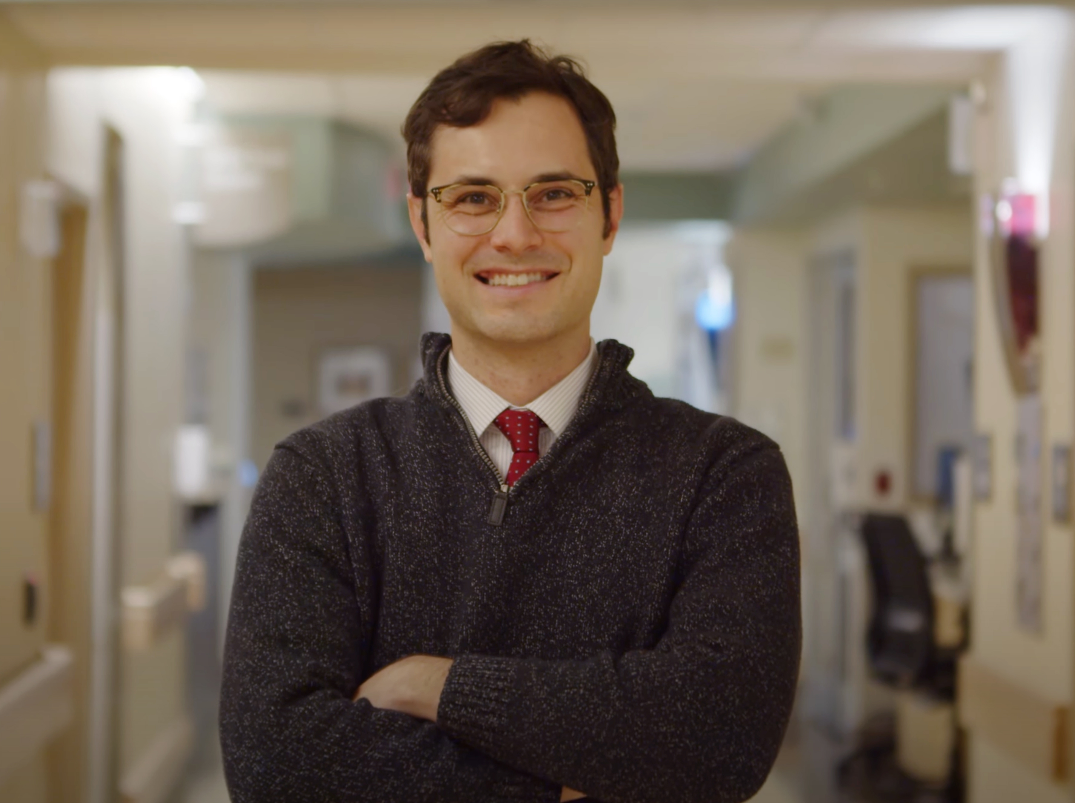Dr. Neil Toupin dressed in a sweater and standing in a hospital hallway