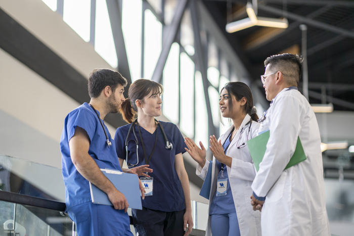 A group of doctors talk to one another in a lobby of a medical building.