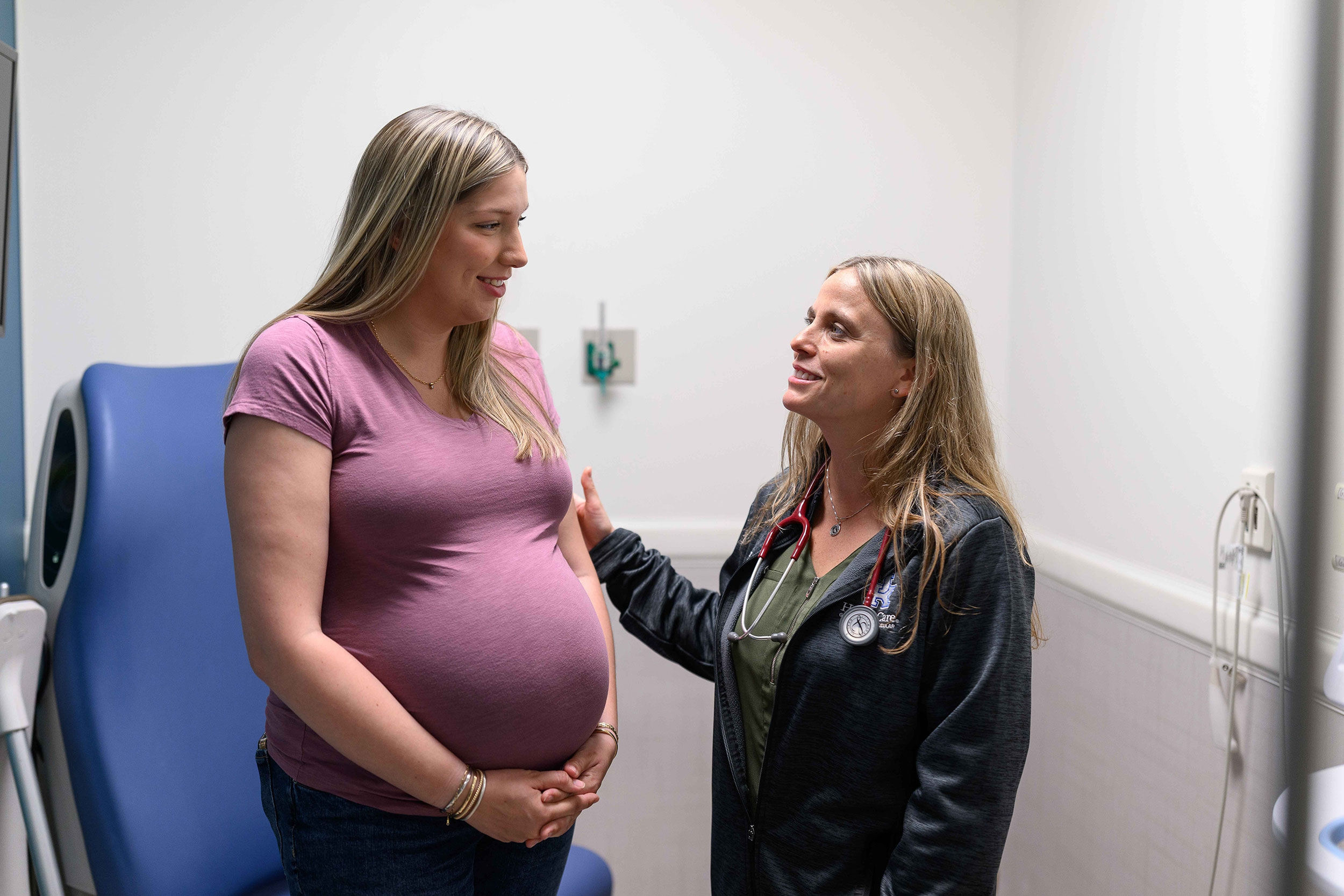 A female doctor speaks with a pregnant patient.