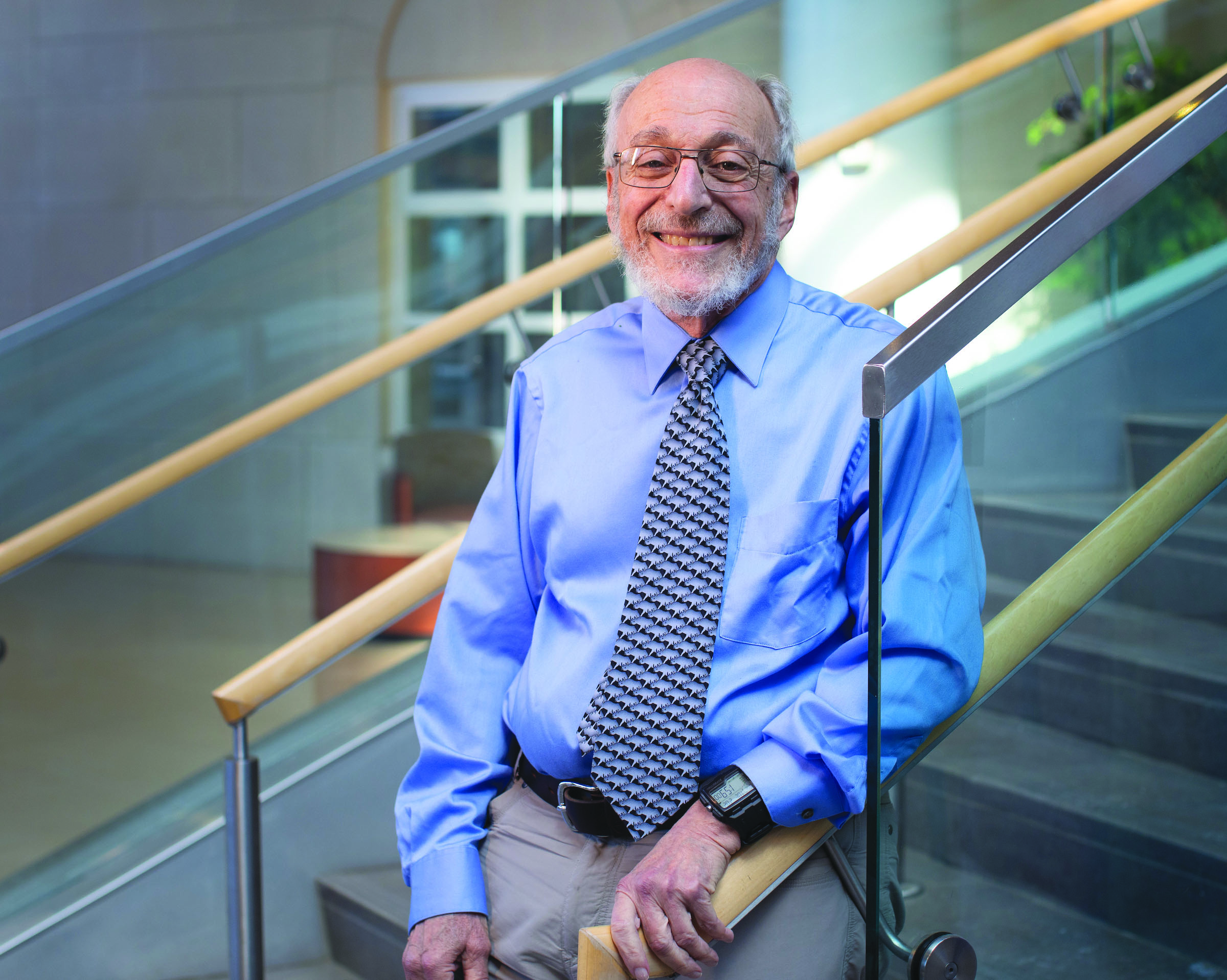 A smiling Dr. Robert Baumann stands on staircase