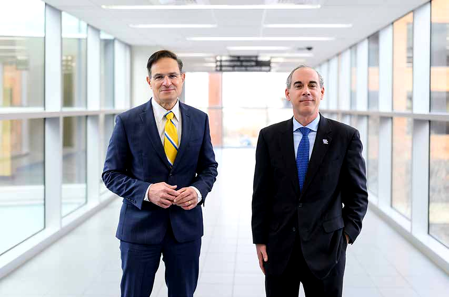 Robert DiPaola, MD, and Eric Monday, PhD, Co-Executive Vice Presidents for Health Affairs, standing in a UK HealthCare corridor.