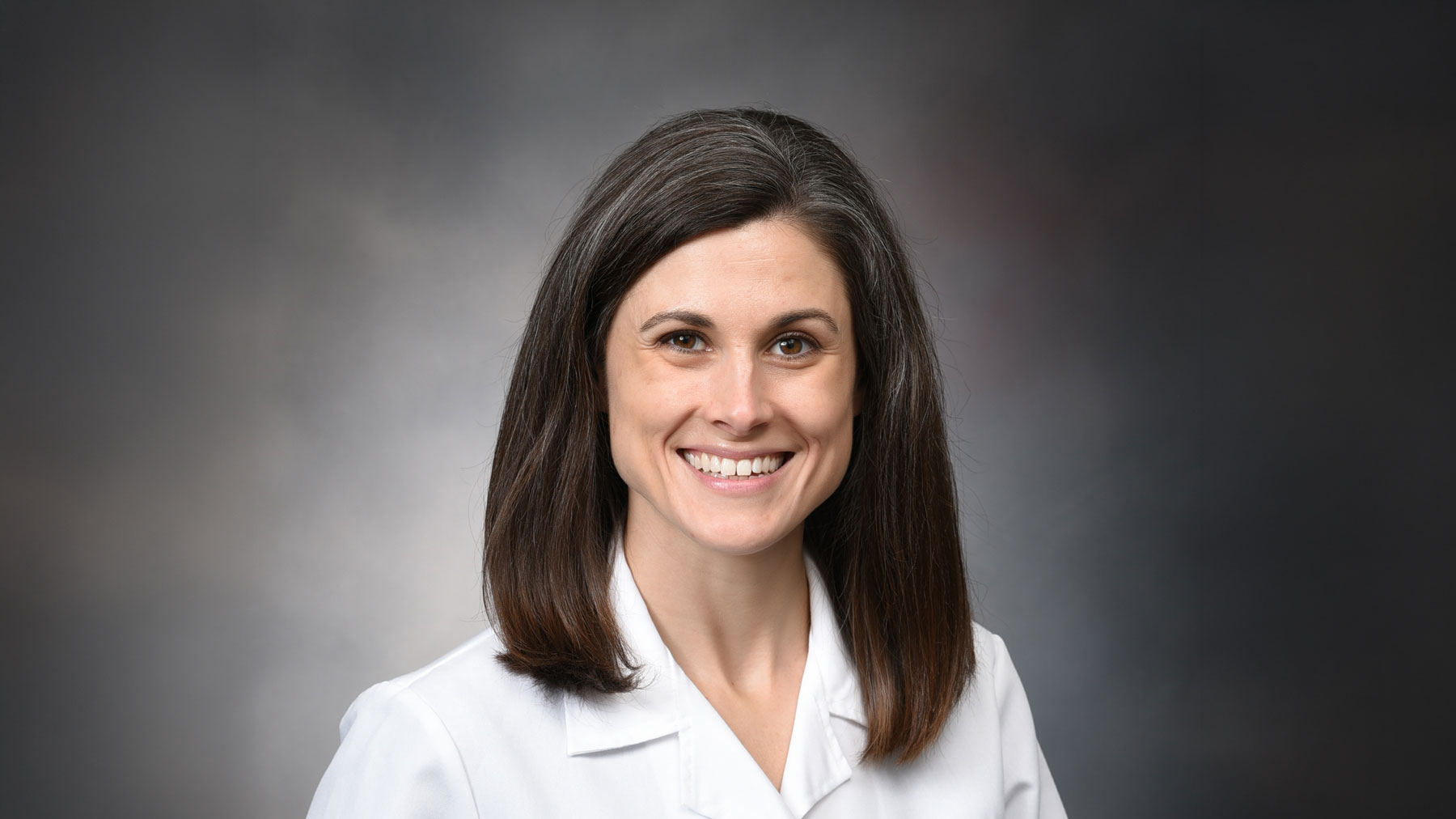 Dr. Alissa Briggs posed against a gray background
