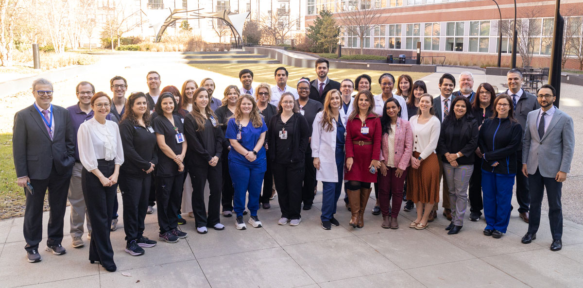 A group of 35 people gathered for a photo taken in a courtyard.