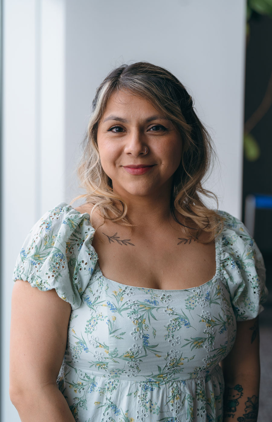 Maria Fuentes poses for a camera. She's wearing a floral dress.