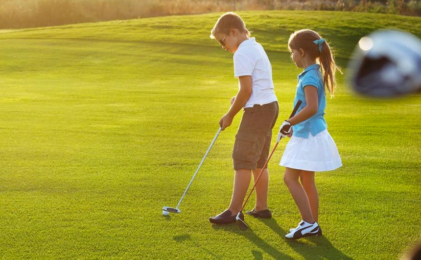 A young boy and girl golfing