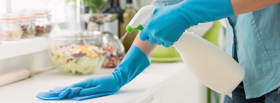 Person disinfecting a counter top. 