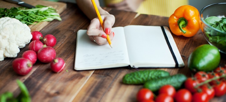 Woman writes in food journal.