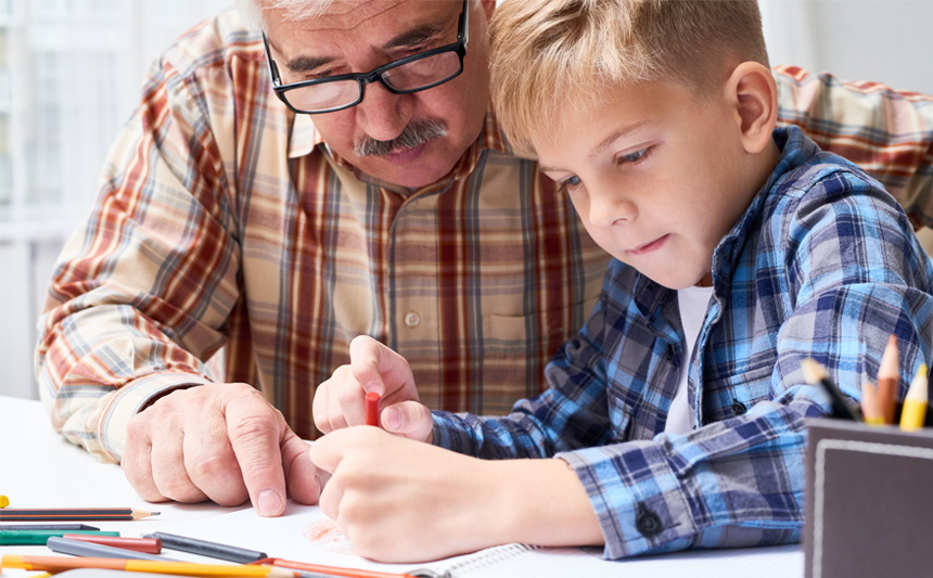 A grandfather helps his grandson with homework.