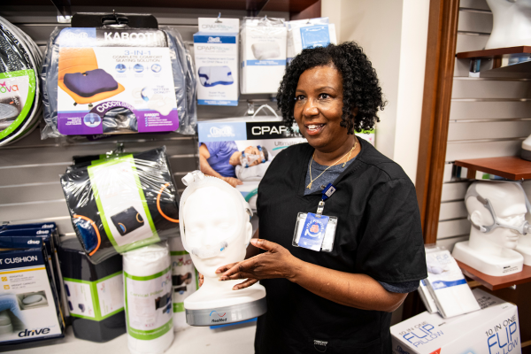 A UK DME employee displays a CPAP in the DME store.