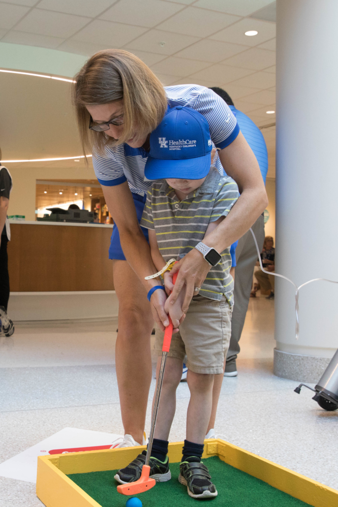 A young patient receives instructions on his swing.