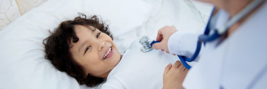 Boy smiling as doctors checks his heart
