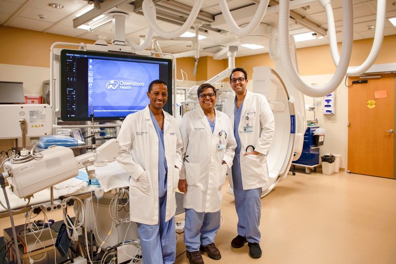 Three providers at Owensboro Health Regional Hospital posing for a photo in their cath lab.