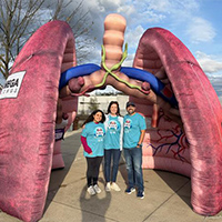staff stand inside giant inflatable lung