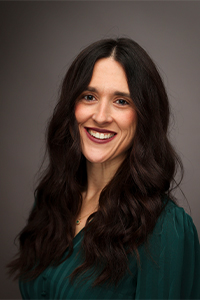 Kendall Fletcher - a woman with long dark hair wearing a green blouse.