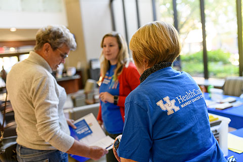 Markey Cancer Center staff and a community member participate in a cancer screening event.