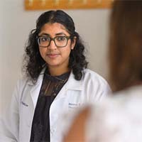 Dr. Reema Patel, MD, listens to patient in clinic.
