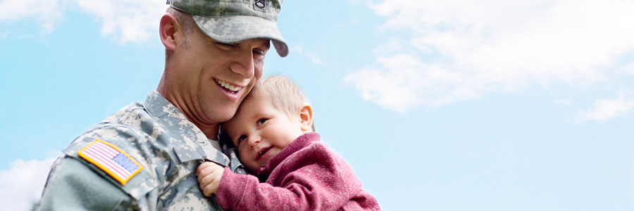 A soldier carries his toddler.