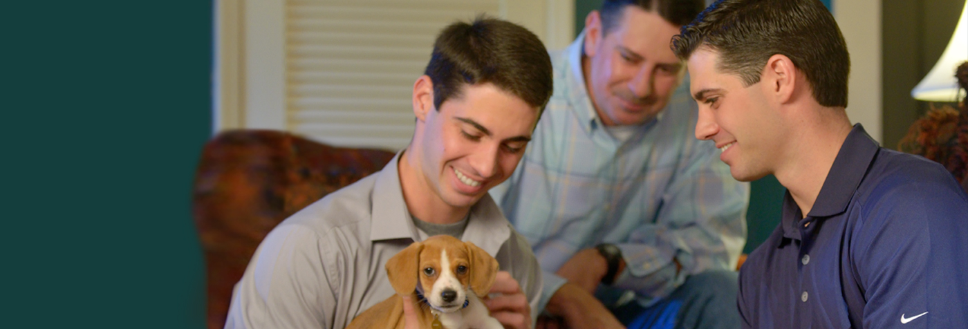 Jon Wes and Gardner Adams with their father and puppy.