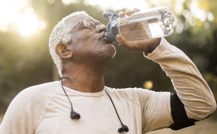 Man drinking water while exercising