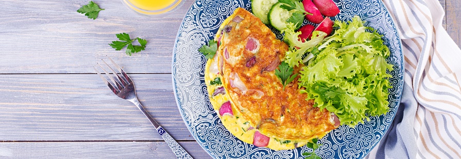 Omelette with small salad on a blue plate.