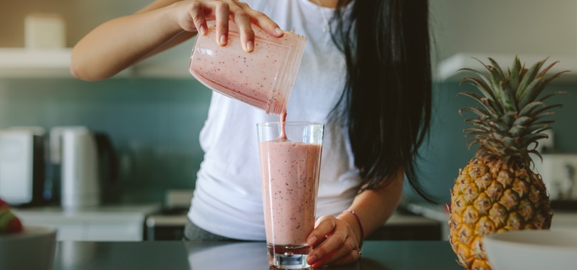 Woman pours a smoothie.