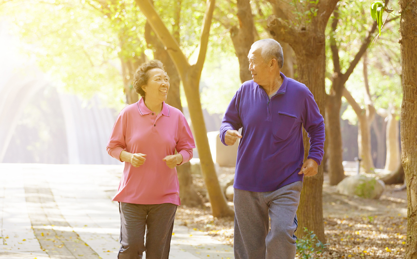 A senior couple walk outdoors.