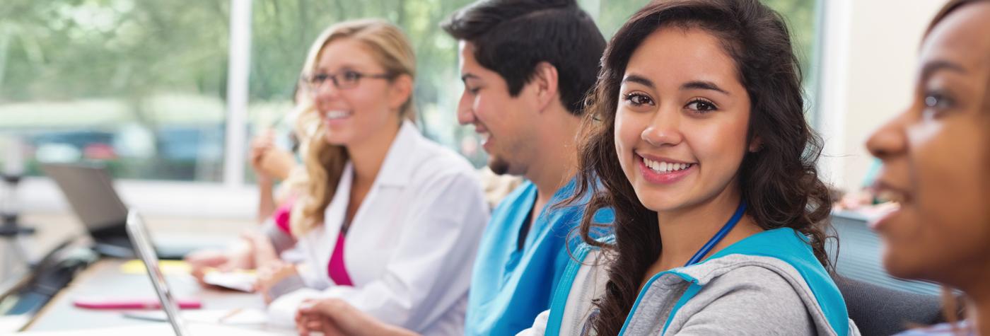 Female student in health sciences class looking toward the camera and smiling