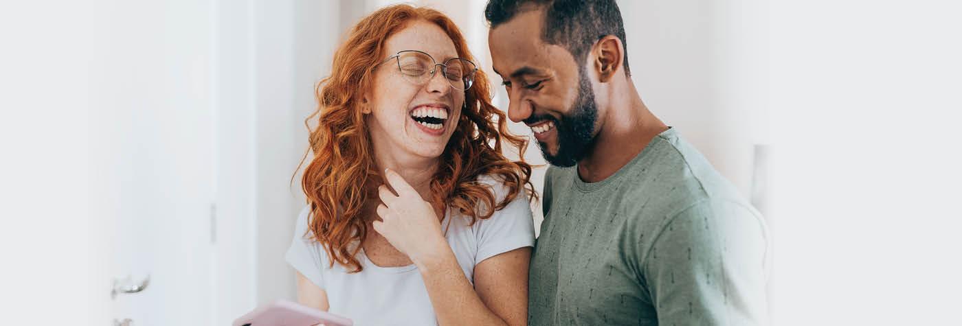 A man and woman laugh together.