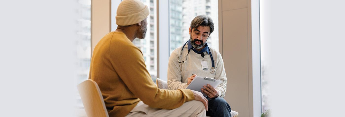 A male doctor and patient speak with one another. 