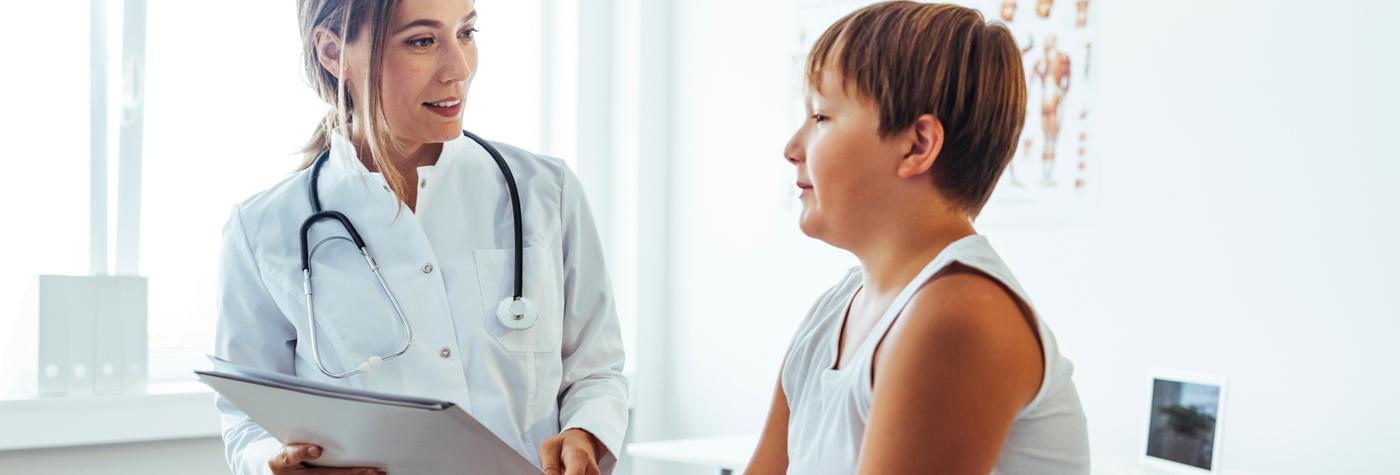A female doctor speaks with a male child. 