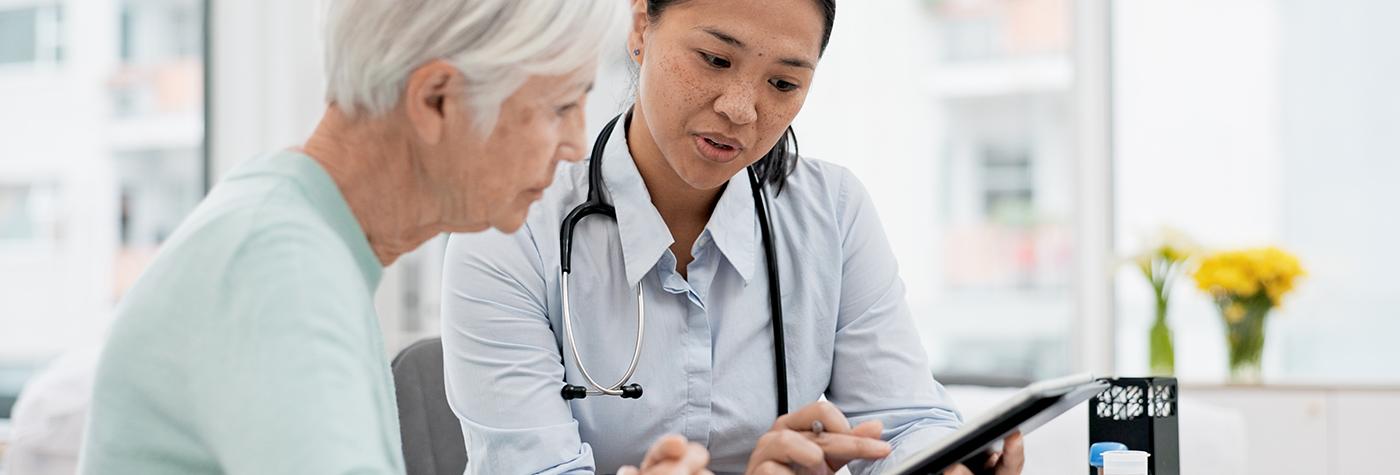 Doctor spends time with a patient reviewing information on a tablet