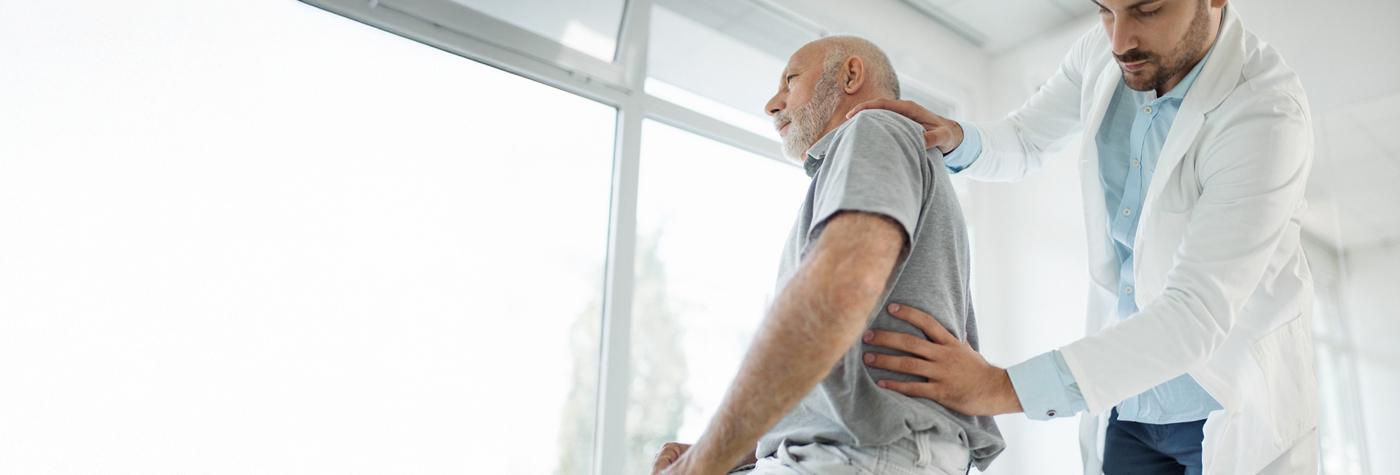 A doctor examines a patient's back