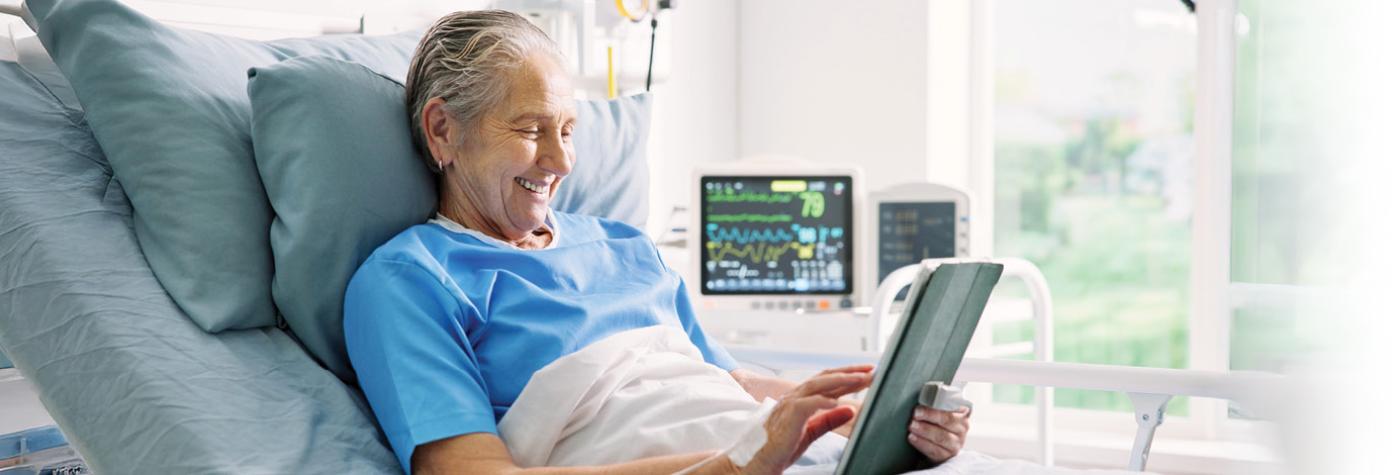 Patient in hospital bed viewing a tablet