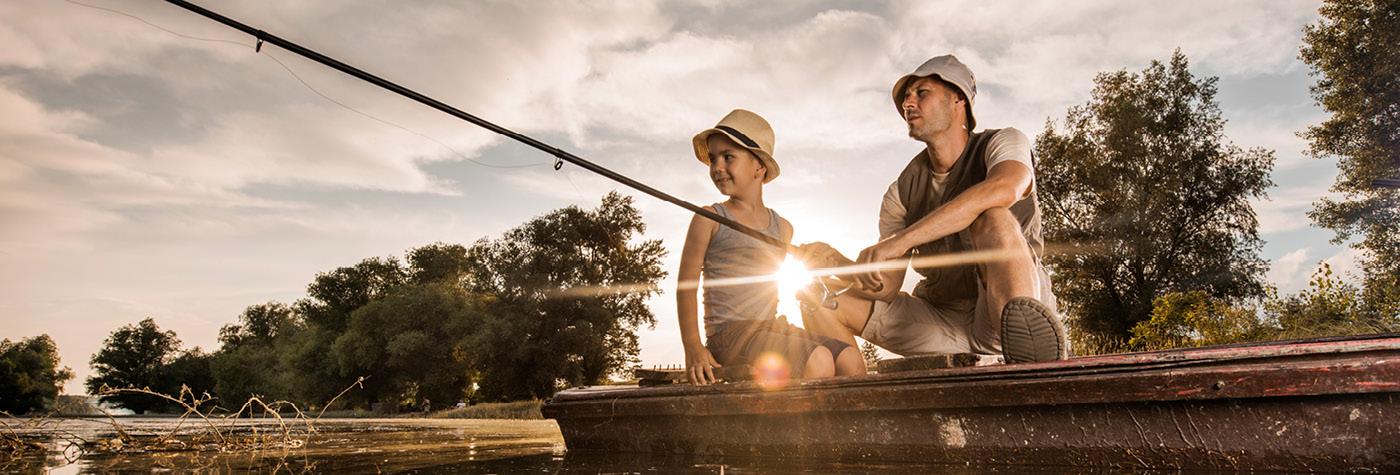 Two people fish off the side of a dock