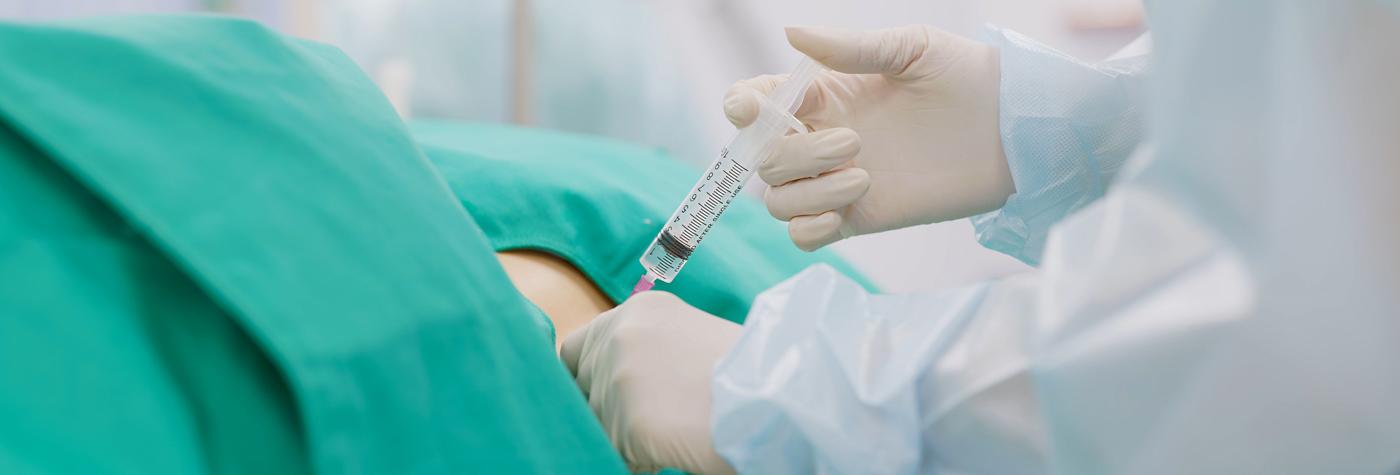 A doctor administers medication via epidural injection