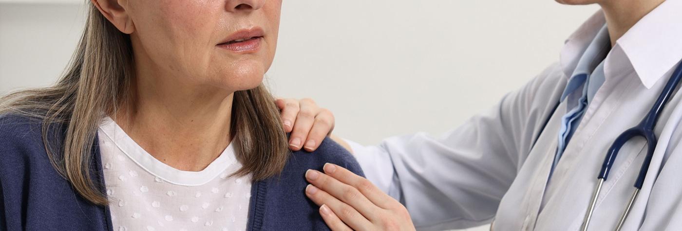 A doctor palpates a patient's shoulder