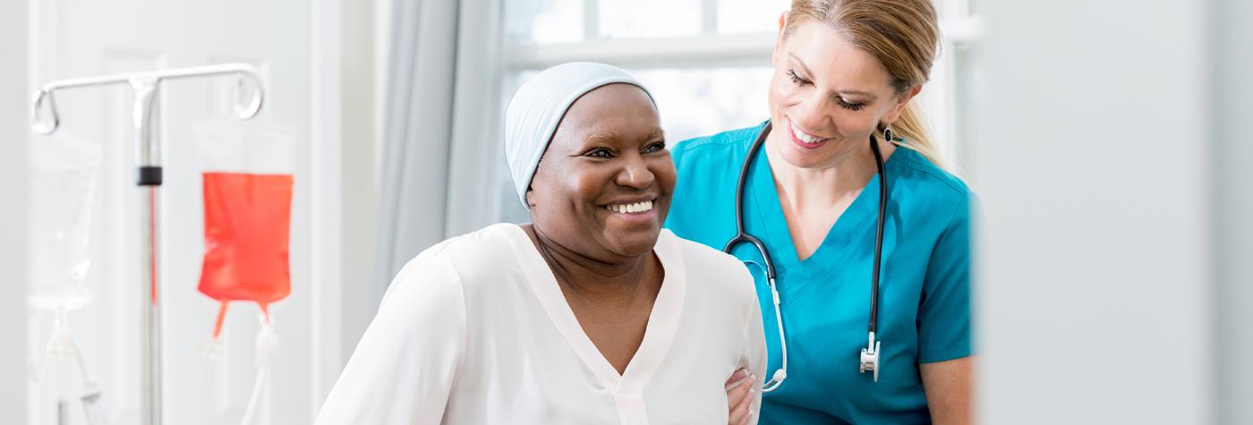 A doctor wearing scrubs assists a patient.