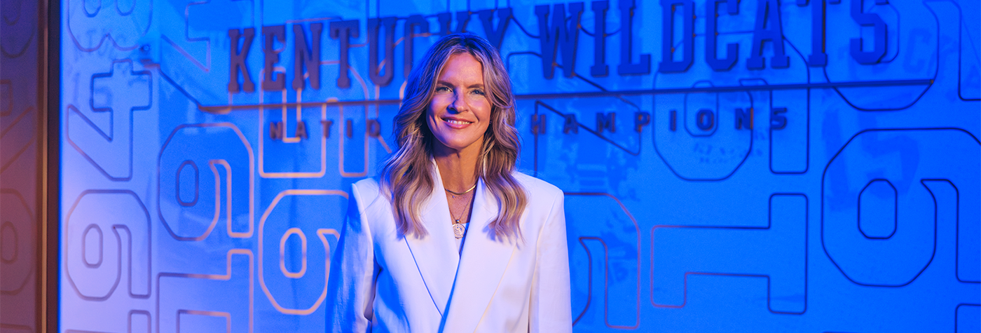 Lee Anne Pope stands in front of a Kentucky Wildcats backdrop.