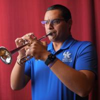 Adiel Nájera plays his trumpet onstage in an auditorium on the University of Kentucky campus.