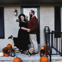 Garrett Dykes and his wife Kristin posing in Halloween costumes on their front step