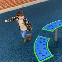 Granger Smith runs around excitedly near a set of blue and yellow benches on a blue foam-padded play area