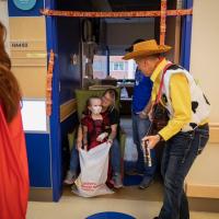 Dr. Scottie Day, dressed as Woody from TOY STORY, singing to kids in a hospital room