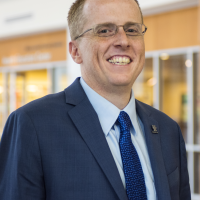 Portrait of Dr. Scottie Day against a windowed background