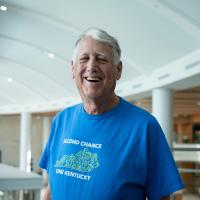 Tom Williams smiling toward a camera, wearing a T-shirt that says Second Chance One Kentucky