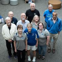 A group of 10 transplant patients gathered in the lobby of UK Albert B. Chandler Hospital for a photo op. A man is on the couch in the background.