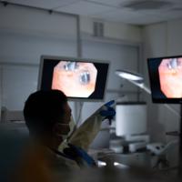 A medical doctor, Ashish Maskey, points to monitors as things happening during a procedure